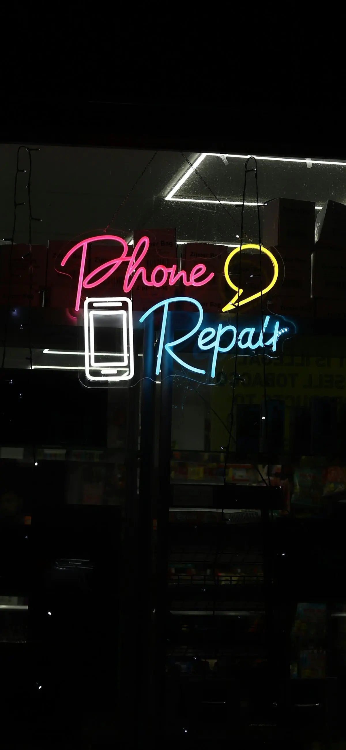 Neon sign for phone repair with phone and speech bubble.